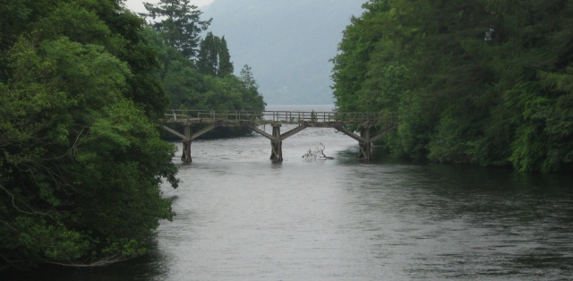 a wooden bridge across a river with trees either side at fort augustus